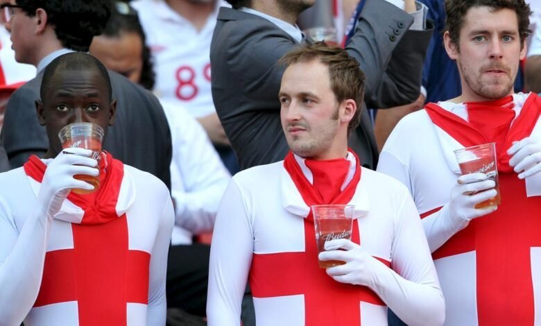 Tres aficionados toman cerveza en un partido de la selección de Inglaterra.